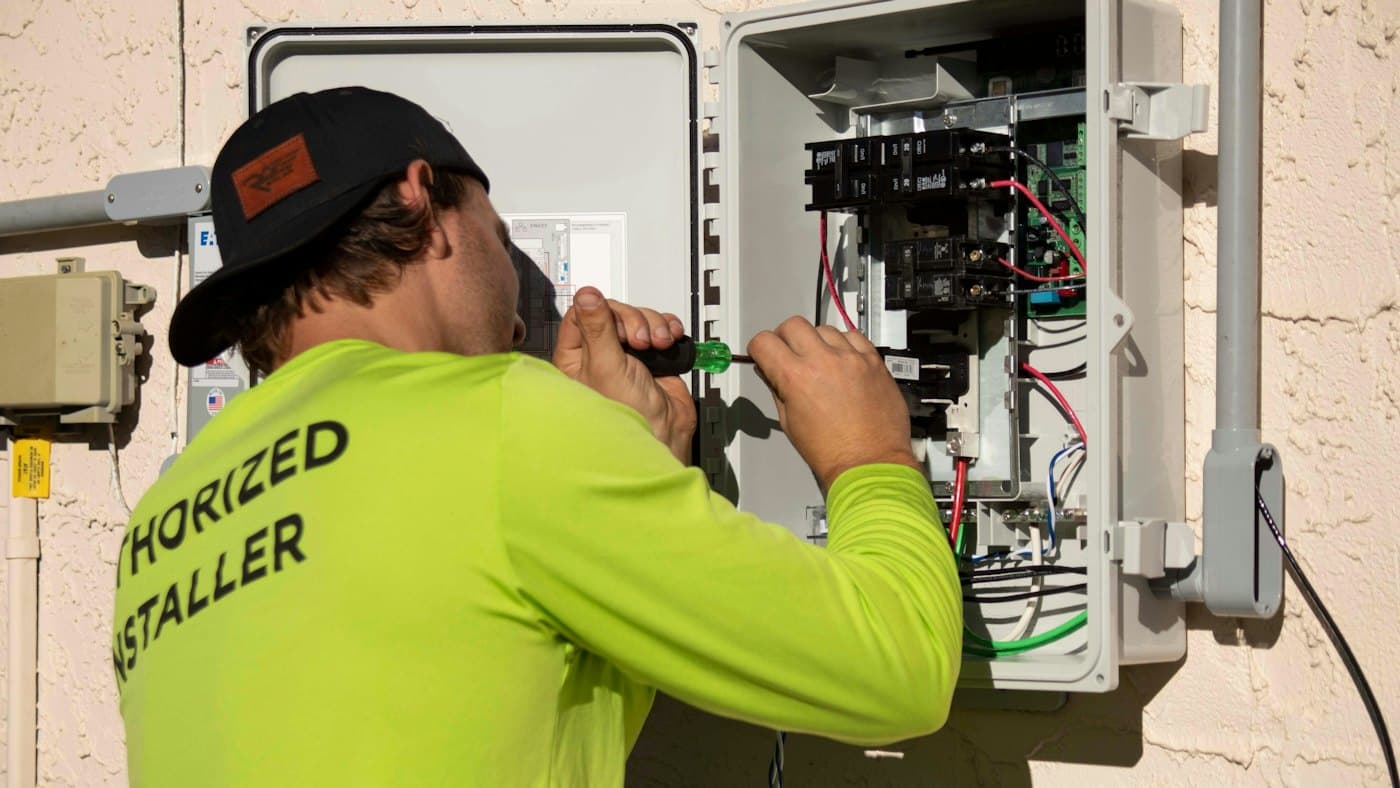 Electrician working on wiring inside a distribution board