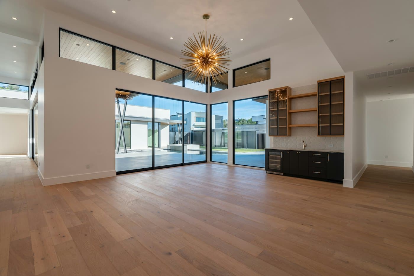 Spacious room with light wooden flooring and large windows