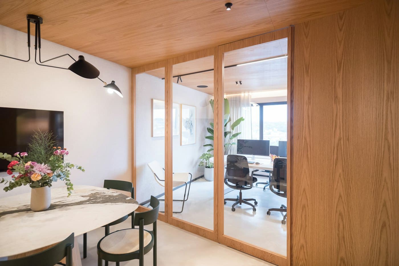 Office with timber-framed glass partition and meeting area